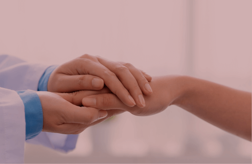 Doctor sosteniendo la mano de un paciente.
